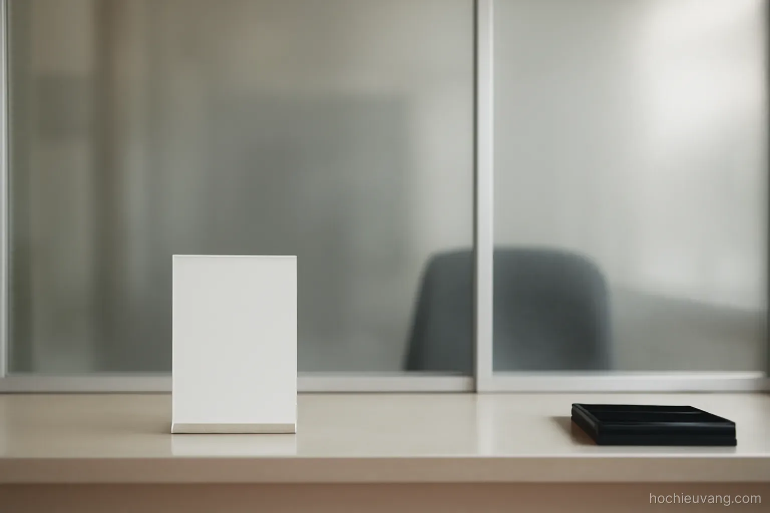 a service counter with a closed sign holder and an empty chair behind frosted glass